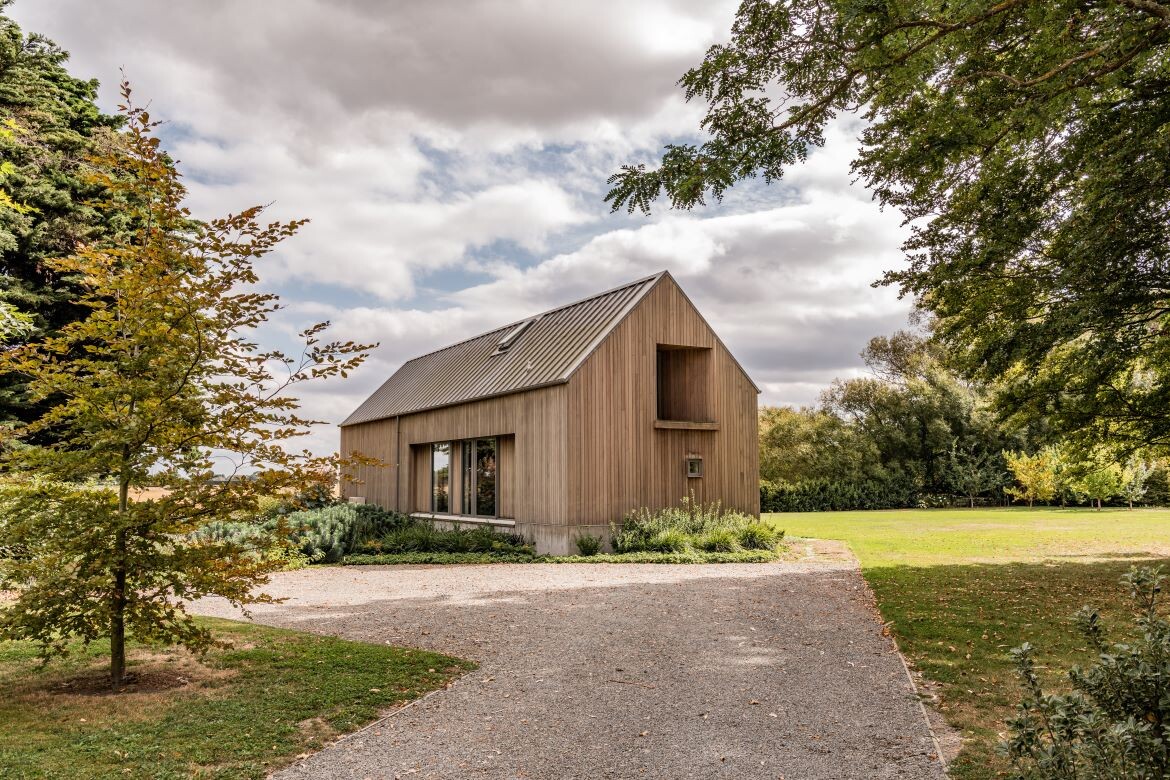 A modern farmhouse perched on the land